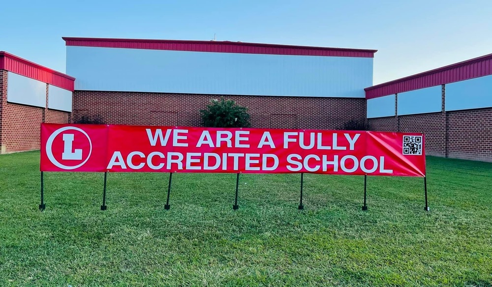 Sign in front of Lancaster High School which reads "We are a fully accredited school"